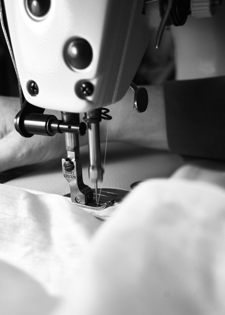 a-sewing-machine-is-in-action-tocirklupya Close-up details of lace, beads, pearls, and threads used in fashion and tailoring. High-quality textile elements and handmade embellishments, showcasing the craftsmanship and elegance of garment design. Perfect for illustrating couture, sewing, fashion production, and artisanal clothing aesthetics.